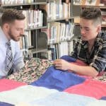 Justin King, high school principal, and Jal Ressler Horst '21, knot a comforter in the library.