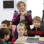 Kindergarten students and eighth graders worked in pairs to knot comforters.