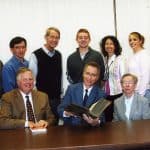 Yoder presents old book printed at the Beck Print Shop in Strasbourg, France (the setting of Yoder's novel, "Margaret's Print Shop") to President Loren Swartzendruber and Lois Bowman (Special Collections Librarian) at Eastern Mennonite University with staff and family looking on. There are only 1-2 others like it in the US.