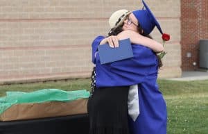 Jodi Hertlzer, senior class sponsors, greets her daughter Arwen, commencement 2021