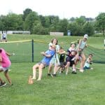 Elementary Field Day with older students setting up and running stations