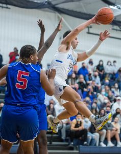 Eastern Mennonite's Adam Hatter passes the ball out to a teammate as he drives to the basket.